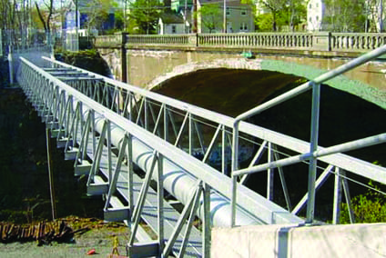 Algonquin Modular Panel Bridge carries utility pipe over rail corridor, Un pont modulaire Ã  panneaux Algonquin supporte un conduit de services publics au-dessus d'un couloir ferroviaire