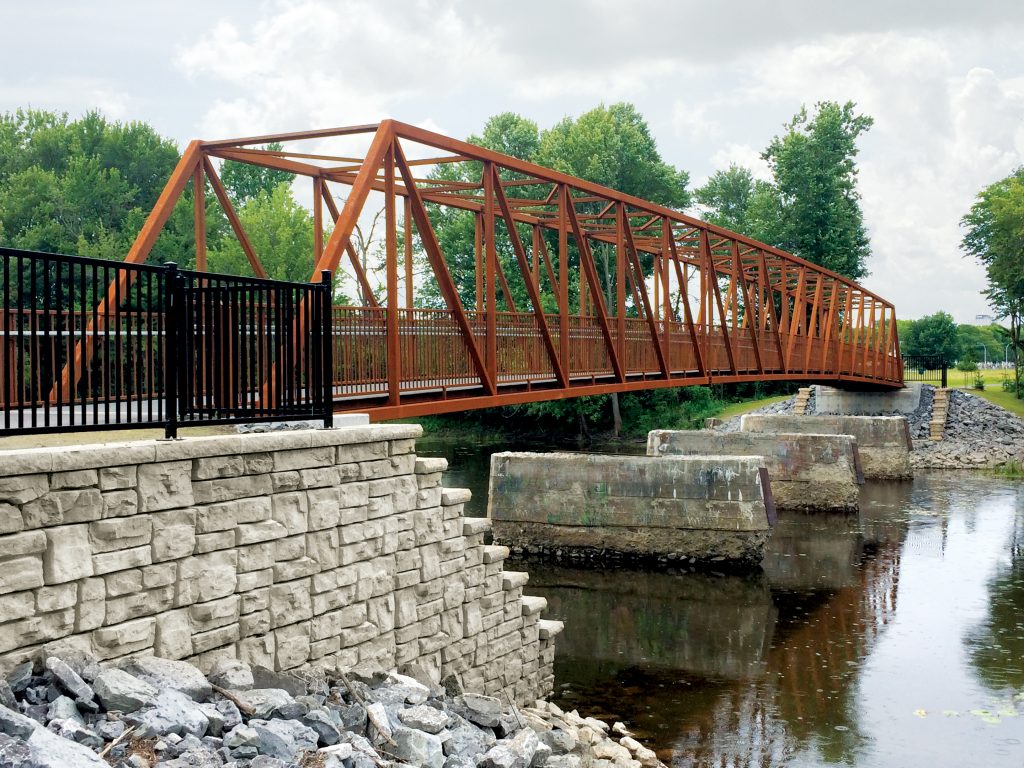 An Algonquin Bridge design: a custom prefabricated trail bridge across a river. Une conception des Ponts Algonquin : un pont de sentier préfabriqué sur mesure au-dessus d'une rivière