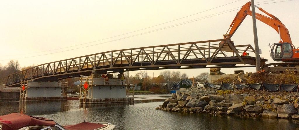 Knuckle Truss Bridge replacement being installed over river, Un pont en treillis classique de remplacement est installé au-dessus d'une rivière