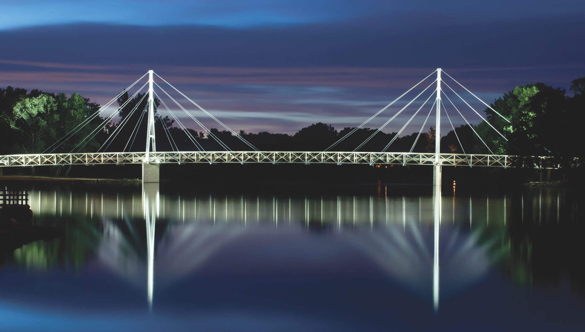 Wide view of cable-stayed pedestrian bridge design with lighting