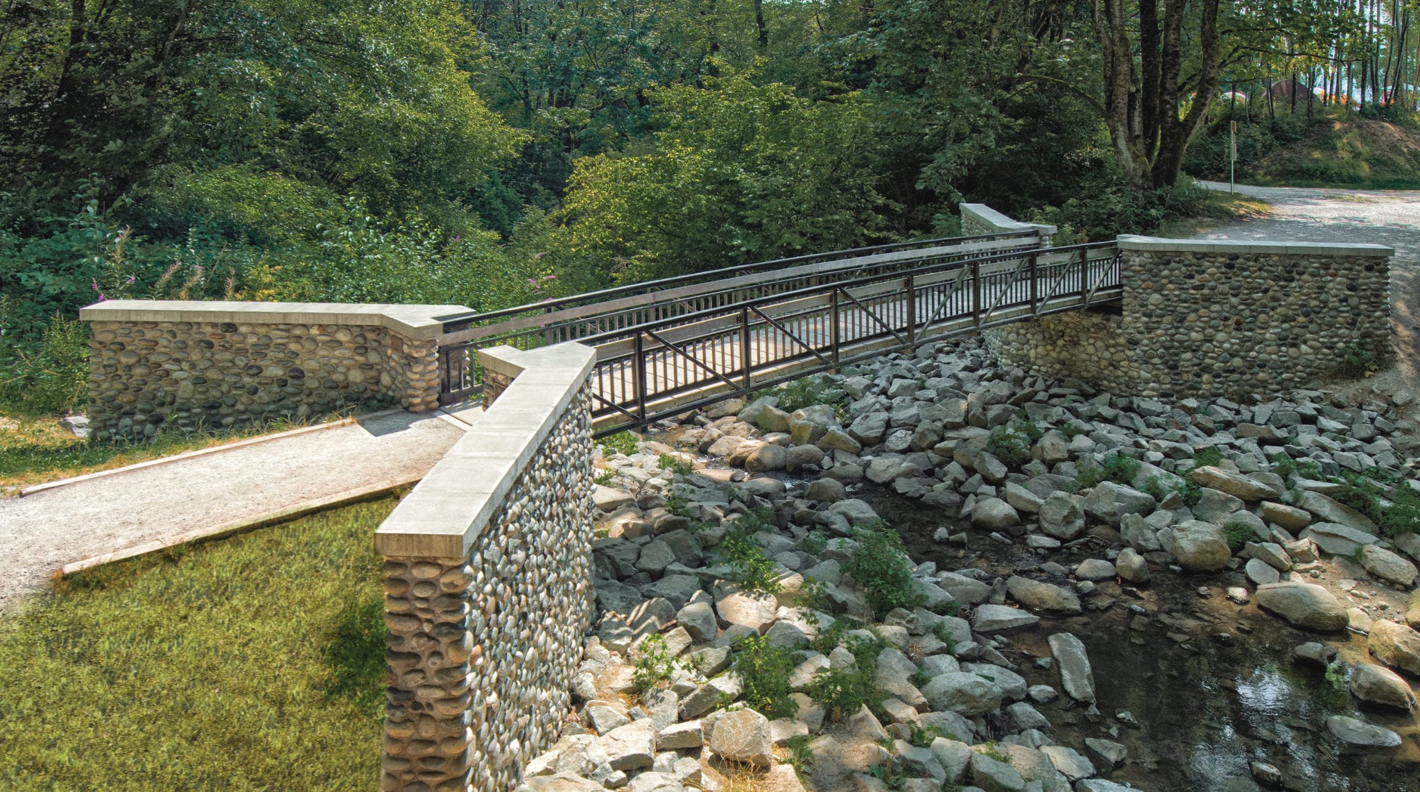 Prefabricated hiking trail bridge design with natural stone abutments