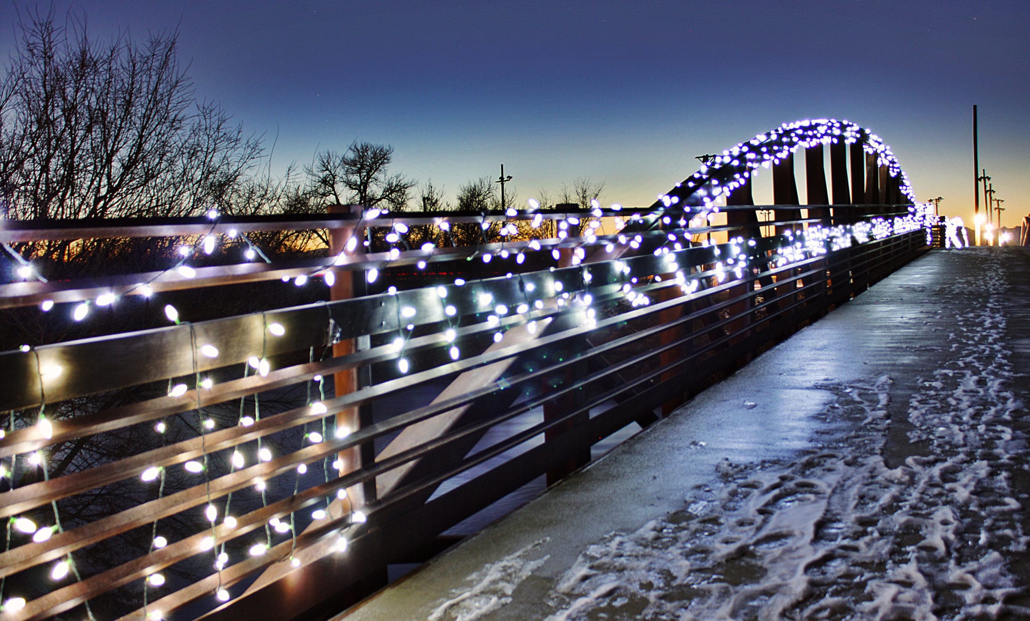Bowstring truss pedestrian bridge decorated with holiday lights