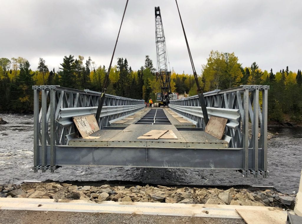 Close up of Bailey Bridge being placed on permanent abutments