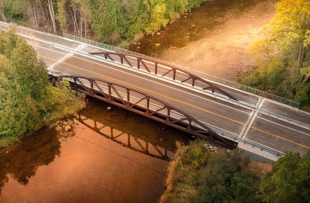 Aerial view of vehicular truss bridge with added sidewalk 