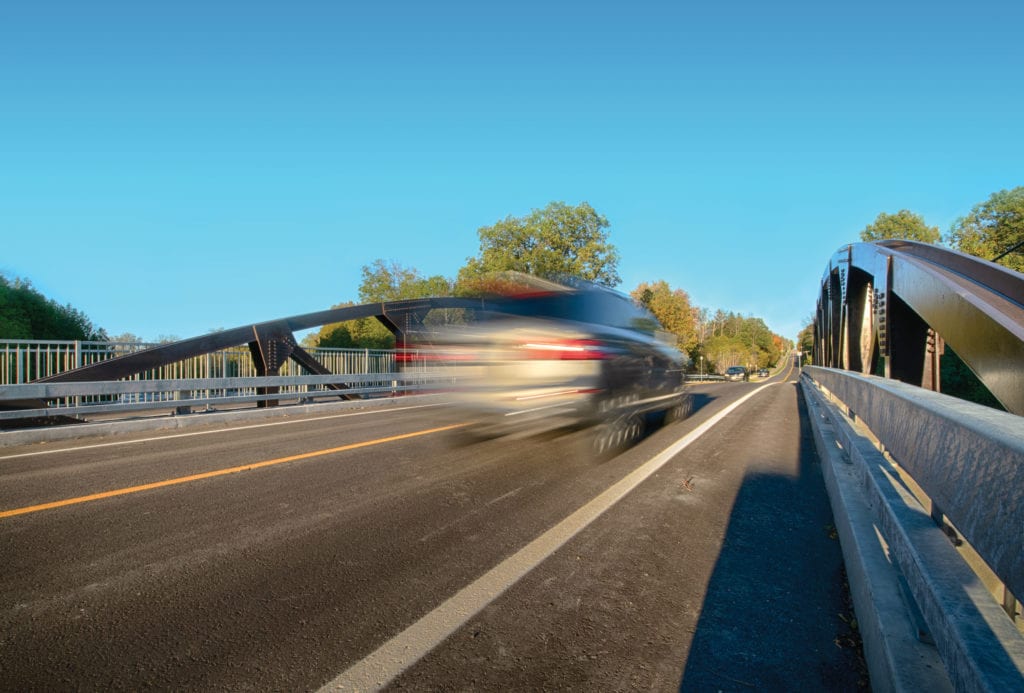Car crossing new prefabricated vehicular truss bridge
