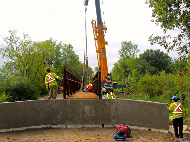 Crane installs new prefab trail bridge