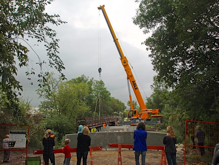 Residents watch installation of new prefab trail bridge