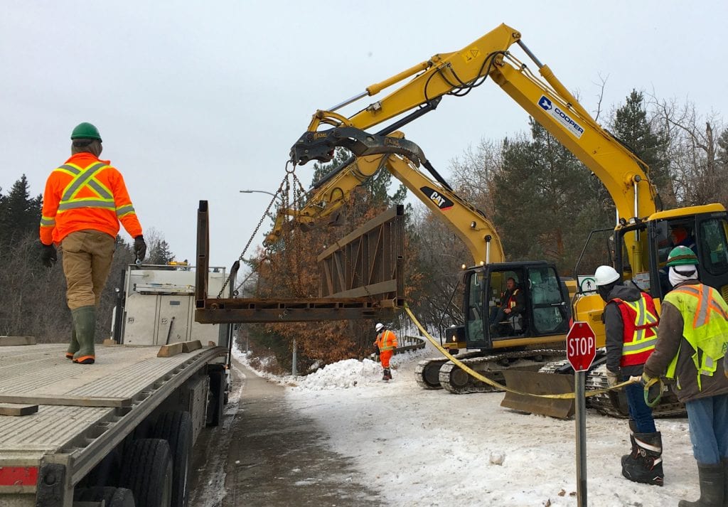 Prefabricated trail bridge unloaded from flatbed
